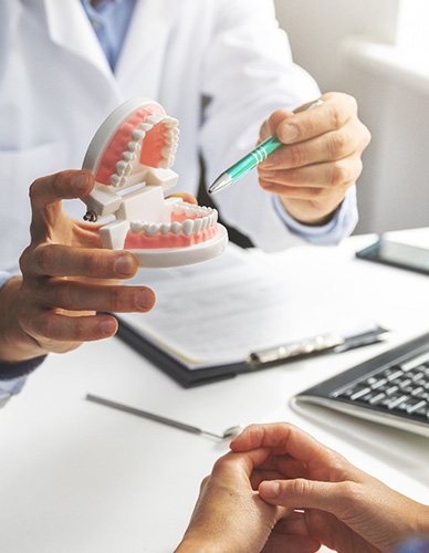 Dentist showing patient model of teeth