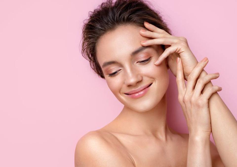 Woman with beautiful skin pictured against pink background