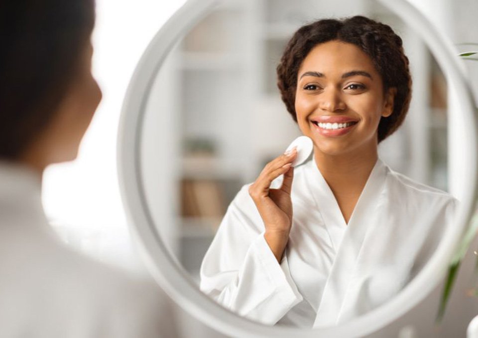 Smiling, happy woman looking at herself in mirror