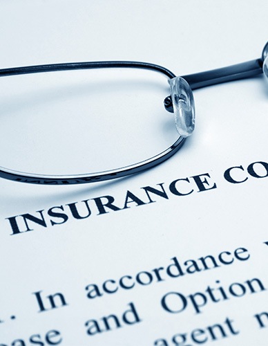 Closeup of Insurance Coverage Info with black framed glasses