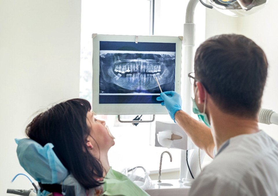 dentist going over digital X-rays with patient   