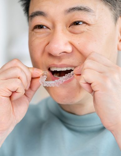 Patient in Richardson putting in their Invisalign aligners