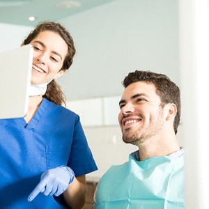 Dentist showing patient image on tablet